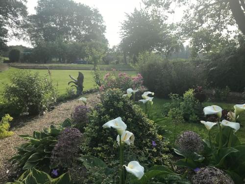 a garden with white flowers and a field in the background at A luxury Boutique Barn set within 2 acre grounds 