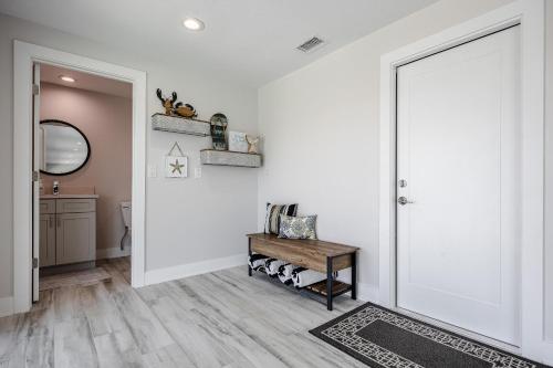 a hallway with a white door and a wooden table at Good Vibes and Tan Lines! Private Beach with Heated Pool - Villa Good Times, Fort Myers Beach in Fort Myers Beach