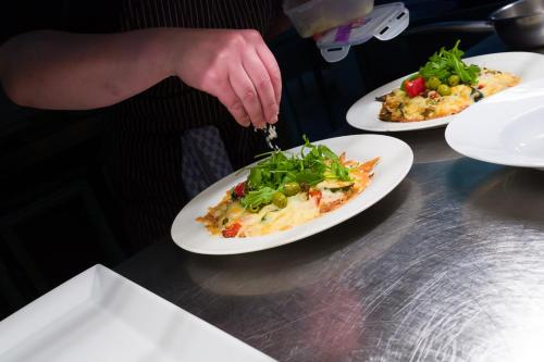 a person cutting a plate of food on a table at Landgasthaus Gieseke-Asshorn in Bohmte