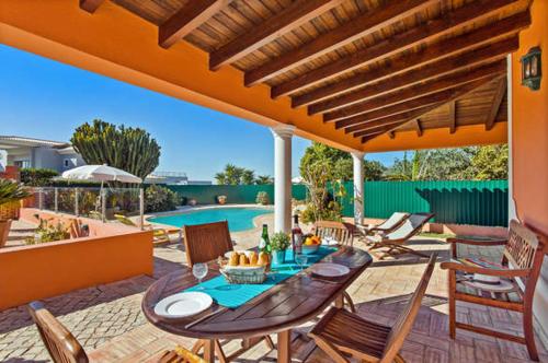 a patio with a table and chairs and a pool at NEW! Poiso do Guincho by GalanteVasques in Carvoeiro
