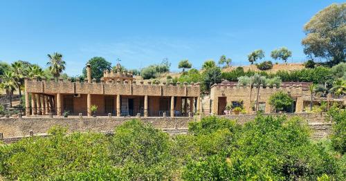 un vieux bâtiment avec des arbres devant lui dans l'établissement VFT Las Piedrecitas, à Hornachuelos