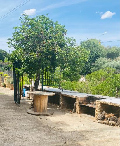 a picnic table and a tree in front of a fence at VFT Las Piedrecitas in Hornachuelos