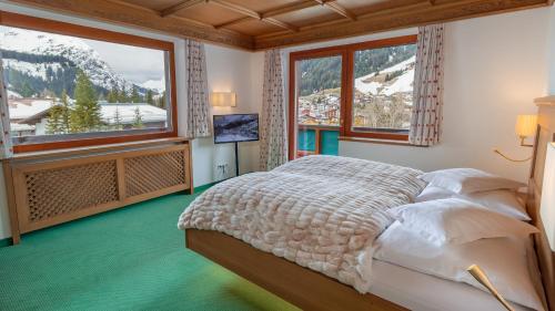 1 dormitorio con 1 cama y vistas a la montaña en Hotel Kristberg en Lech am Arlberg