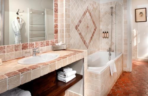 a bathroom with a sink and a bath tub at Le Clair de la Plume - Teritoria in Grignan