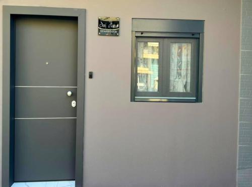 a door with a window next to a building at Sevi House Suite in Thessaloniki