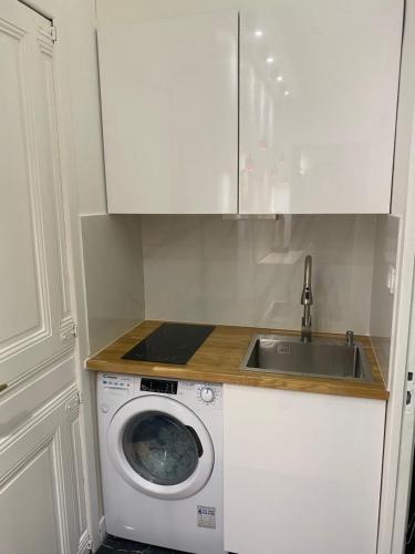 une cuisine avec une machine à laver et un évier dans l'établissement joli studio 2/4 personnes, à Paris
