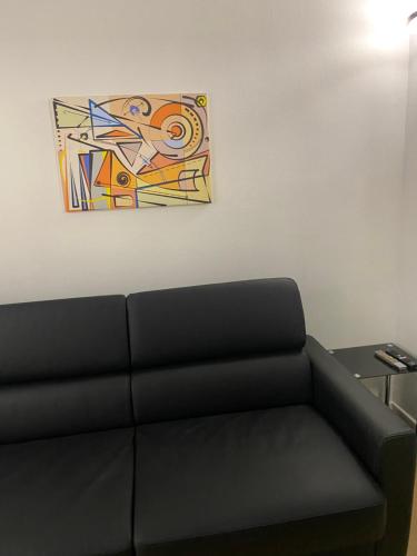 un tableau accroché au mur à côté d'un canapé dans l'établissement joli studio 2/4 personnes, à Paris