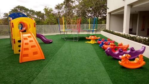 a playground with different types of play equipment on grass at Park Veredas in Rio Quente