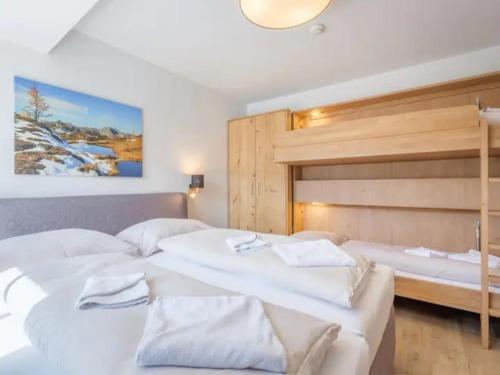 a bedroom with two beds and a large headboard at Tauernlodge Sonnblick Top 3 in Mühlbach am Hochkönig