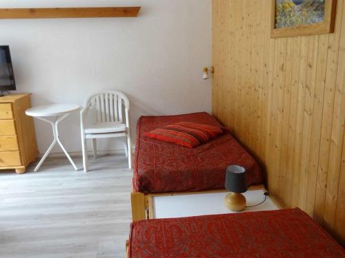 a room with two beds and a table and a chair at Studio Valloire, 1 pièce, 4 personnes - FR-1-263-38 in Valloire