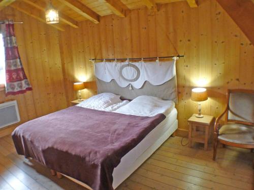 une chambre avec un lit et deux chaises dans une pièce dans l'établissement Chalet familial avec salle de jeux, parking et WiFi - FR-1-629-1, à Samoëns