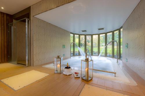 baño grande con ducha y ventana grande. en Rothay Garden Hotel & Riverside Spa en Grasmere
