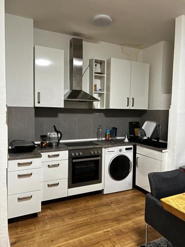 cocina con armarios blancos y lavavajillas en Zentral Hochparterre garten, en Wuppertal