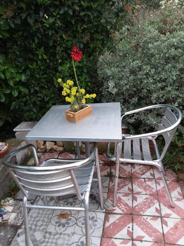 d'une table et de deux chaises avec un vase et une fleur. dans l'établissement Chambre d'hôtes ici, à Bédoin