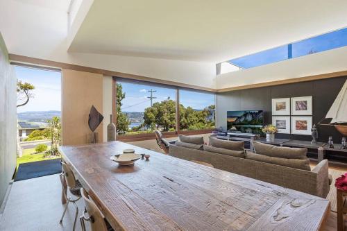 a large living room with a large wooden table at 24 Hill Street- Unique 2 bedroom pet friendly home in Merimbula