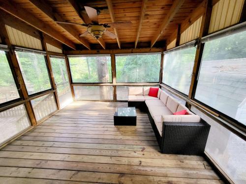 a screened in porch with a couch in a room with windows at 4-Bedroom House Close to Beach in Salisbury