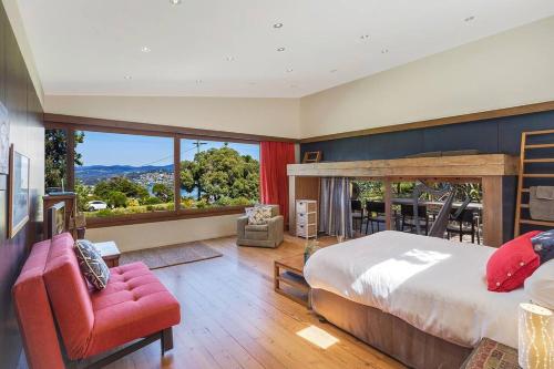a bedroom with a large bed and a large window at 24 Hill Street- Unique 2 bedroom pet friendly home in Merimbula