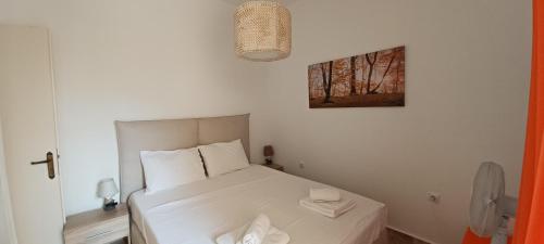 a bedroom with a white bed and a picture on the wall at Angel's Place by the Sea in Diakopto