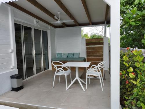una mesa blanca y sillas en un patio en Studio Ti Bambou, en La Trinité