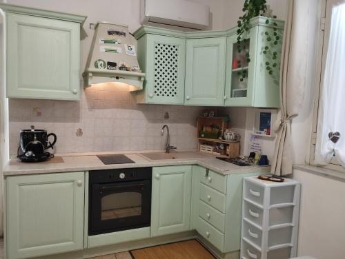 a kitchen with green cabinets and a sink at Casetta la Terrazza in Civita Castellana