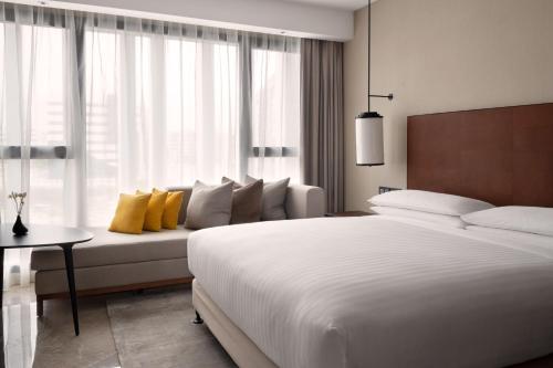 a bedroom with a large white bed and a couch at Tunis Marriott Hotel in Tunis