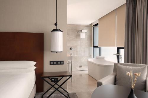1 dormitorio con 1 cama y baño con bañera en Tunis Marriott Hotel en Túnez