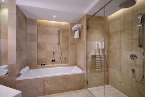 a large bathroom with a tub and a shower at Tunis Marriott Hotel in Tunis