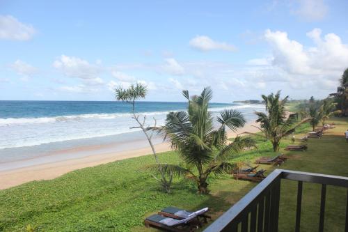 a view of the beach from the balcony of a resort at The Long Beach Resort & Spa in Koggala