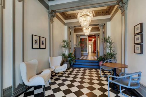 a hallway with chairs and a checkerboard floor at Trilogy Hotel Montgomery, Autograph Collection in Montgomery