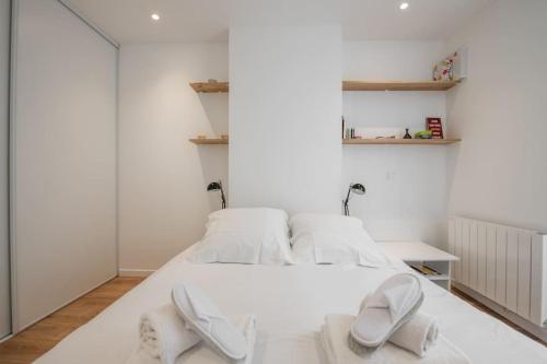 deux lits dans une chambre aux murs blancs dans l'établissement 49 Rochechouart - Cozy apartment near Montmartre, à Paris