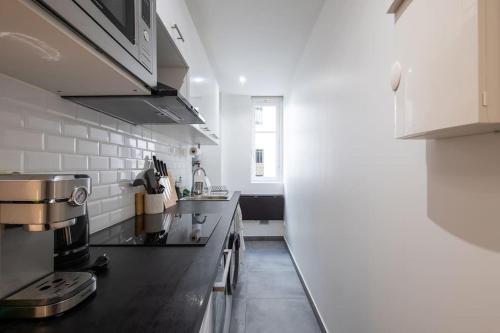 une cuisine avec une cuisinière et un comptoir dans l'établissement 49 Rochechouart - Cozy apartment near Montmartre, à Paris