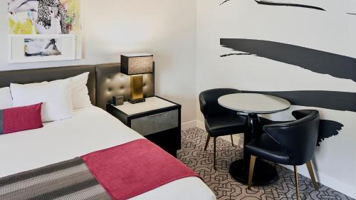 a bedroom with a bed and a desk and a table at Devine Unit by Planet Hollywood Casino Strip Las Vegas in Las Vegas