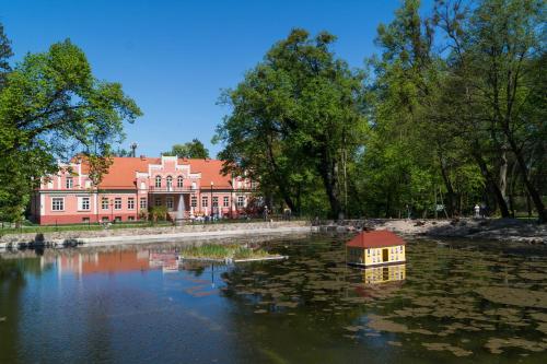 a house in the water in front of a large building at Apartament Słowińców 52 in Wejherowo