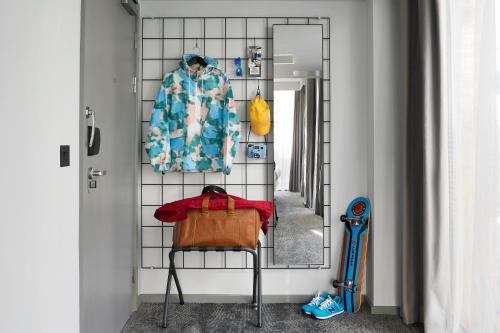 ein Zimmer mit einem Spiegel und einem Stuhl in einem Zimmer in der Unterkunft Moxy Manchester City in Manchester