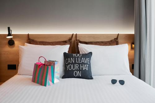 a bed with a bag and some pillows on it at Moxy Manchester City in Manchester