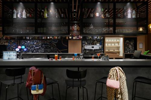 a bar with black stools and a counter at Moxy Manchester City in Manchester