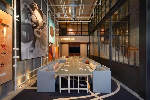 a long dining room with a long table and chairs at Moxy Sydney Airport in Sydney