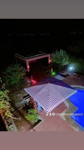 a lit up umbrella in a yard at night at La Novia Marrakech in Tahannout