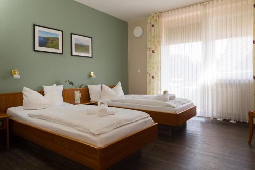 um quarto com 2 camas e uma janela em Landgasthaus Gieseke-Asshorn em Bohmte
