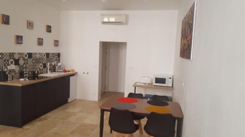 une cuisine avec une table et des chaises dans une pièce dans l'établissement T2 60 m² - Au cœur de tout, à Gignac