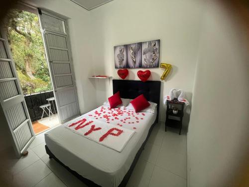 a bedroom with a bed with red roses on it at Hotel San Martin Plaza in Villeta