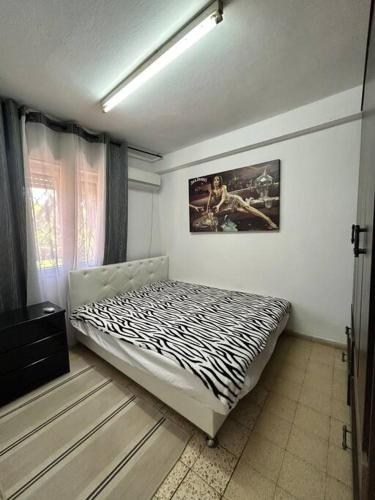 uma cama com estampa de zebra num quarto com uma janela em dgania lux em Qiryat H̱ayyim