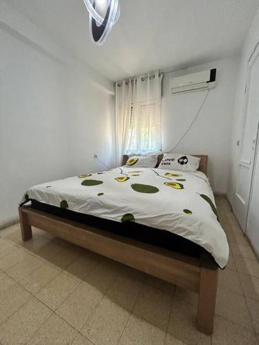 um quarto com uma cama com um edredão branco em dgania lux em Qiryat H̱ayyim