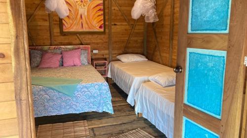 a room with two beds in a cabin at Arcoiris Casahostal in San Bernardo del Viento