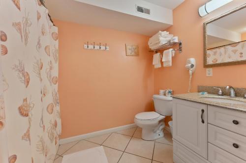 a bathroom with a toilet and a sink and a mirror at Nw Condo Across Beach Pool & Parking in North Wildwood