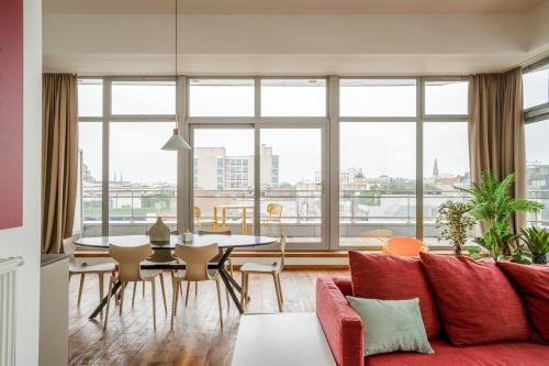 een woonkamer met een rode bank en een tafel en stoelen bij Smartflats - Central Antwerp in Antwerpen