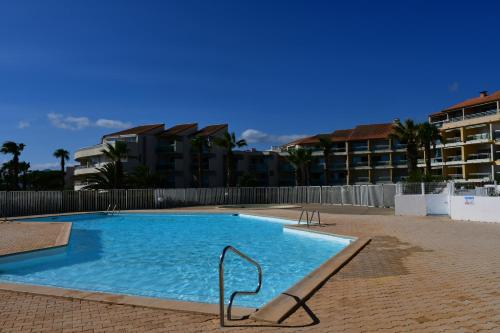 une grande piscine devant un immeuble dans l'établissement Les Goélettes location saisonnière, à Saint-Cyprien