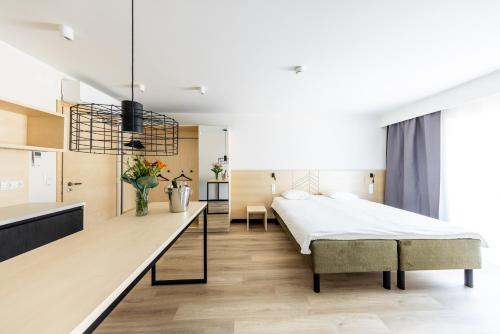 a bedroom with a large bed and a kitchen at Saaremaa Rannahotell ' Beach Hotel in Mändjala