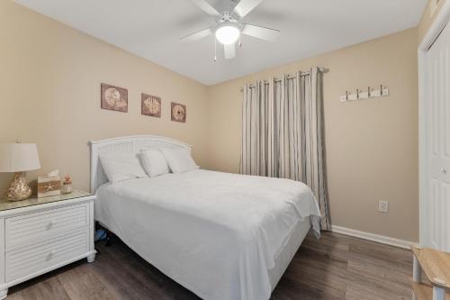 a bedroom with a white bed and a ceiling fan at Nw Condo W Private Balcony & Pool in North Wildwood