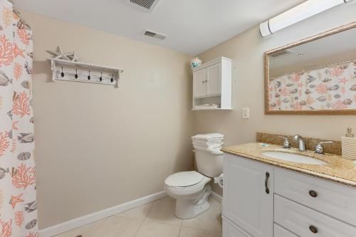 a bathroom with a toilet and a sink and a mirror at Nw Condo W Private Balcony & Pool in North Wildwood